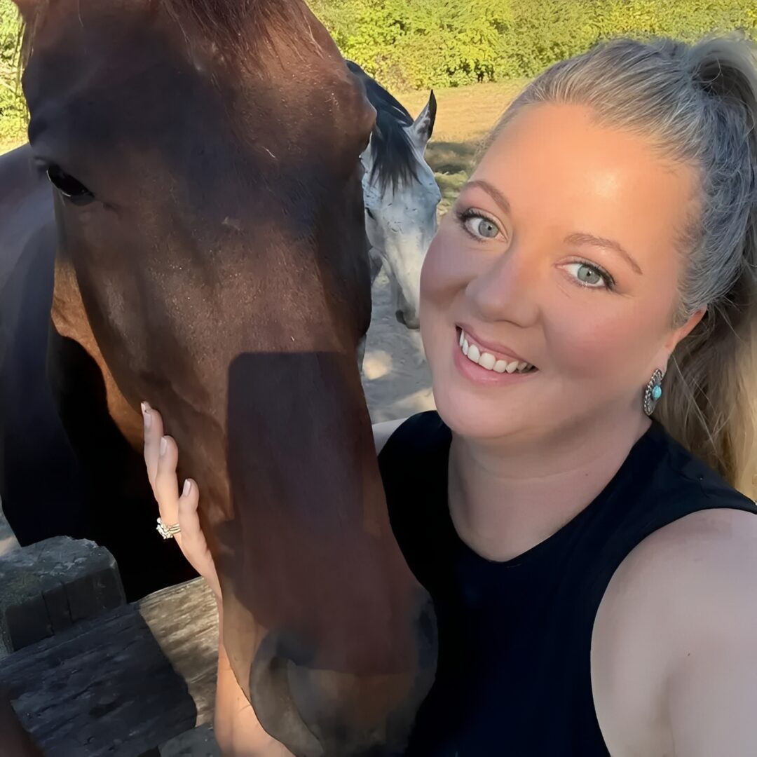 Woman petting brown horse affectionately