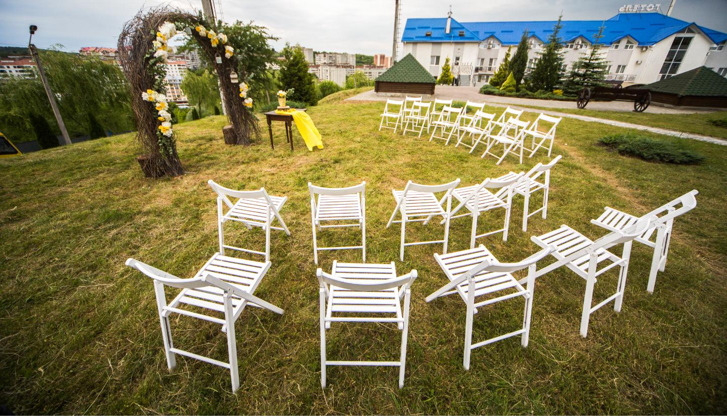 Outdoor wedding ceremony with white chairs