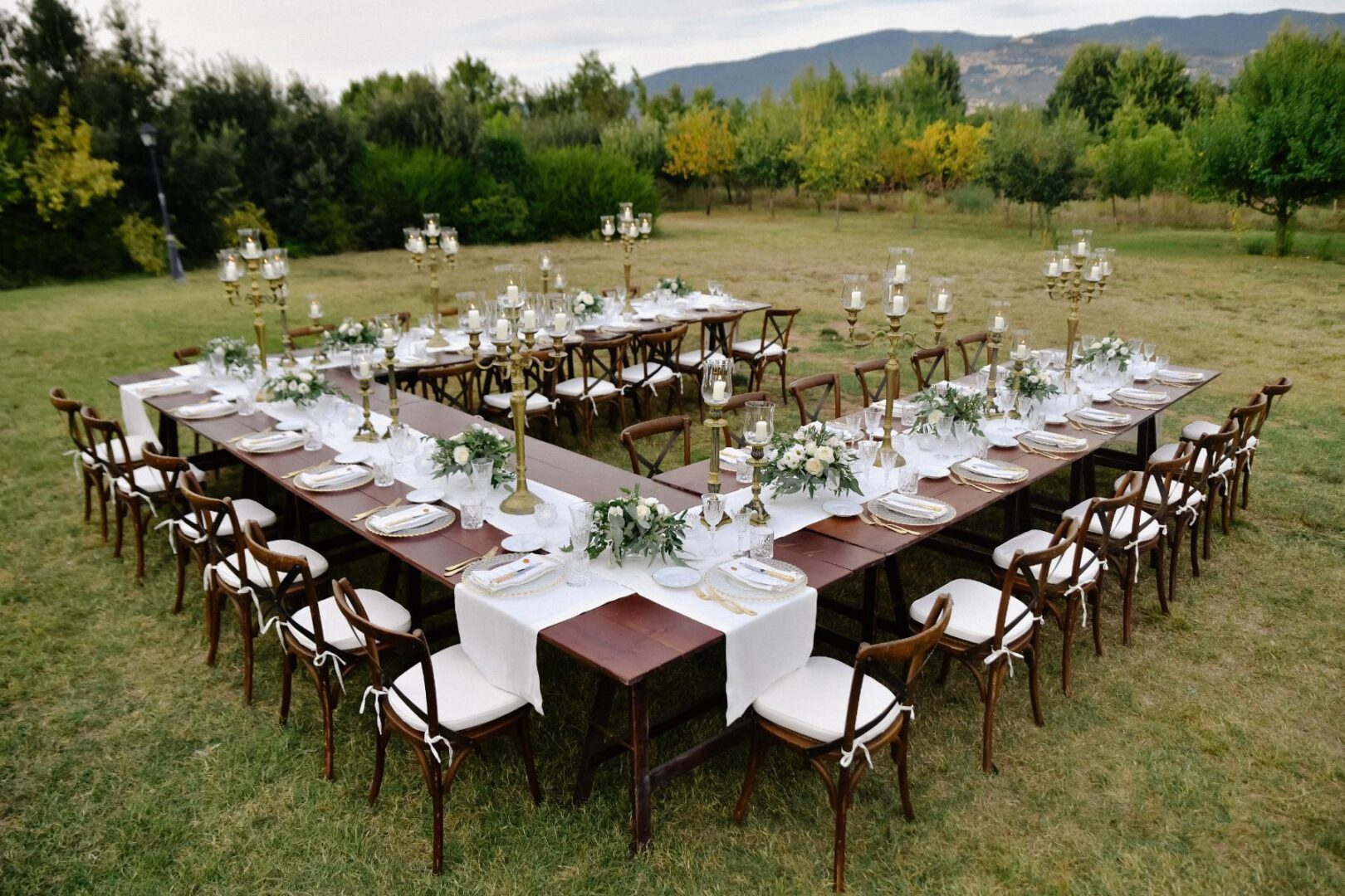 Outdoor U-shaped wedding reception table setup