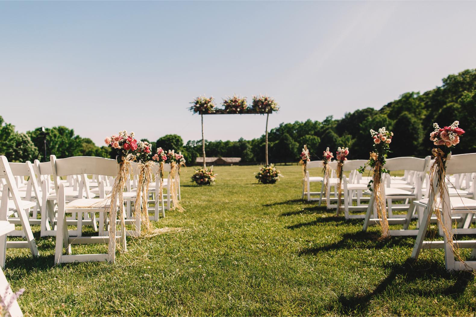 Outdoor wedding ceremony arch and chairs