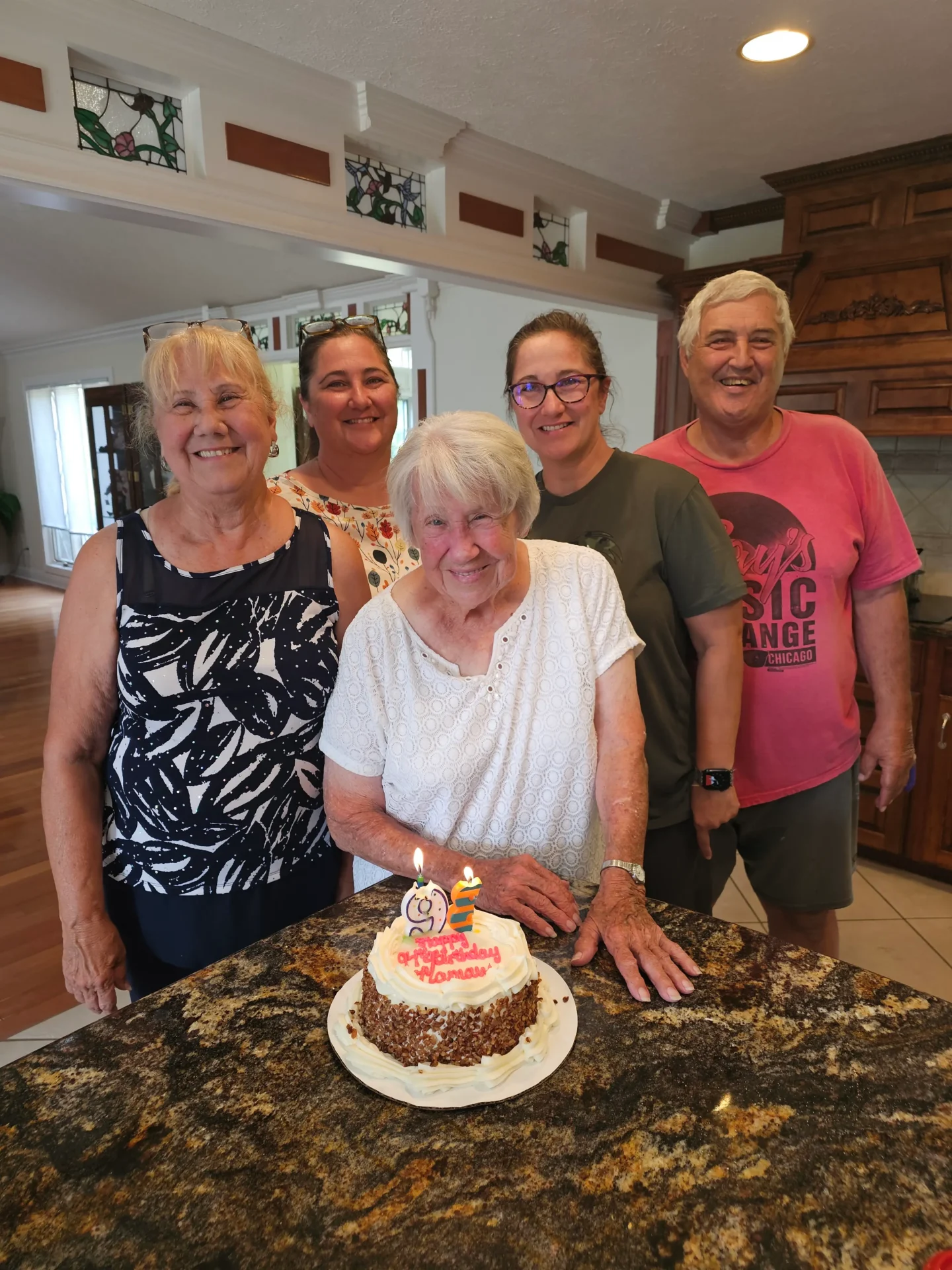 Group smiling around birthday cake with candles