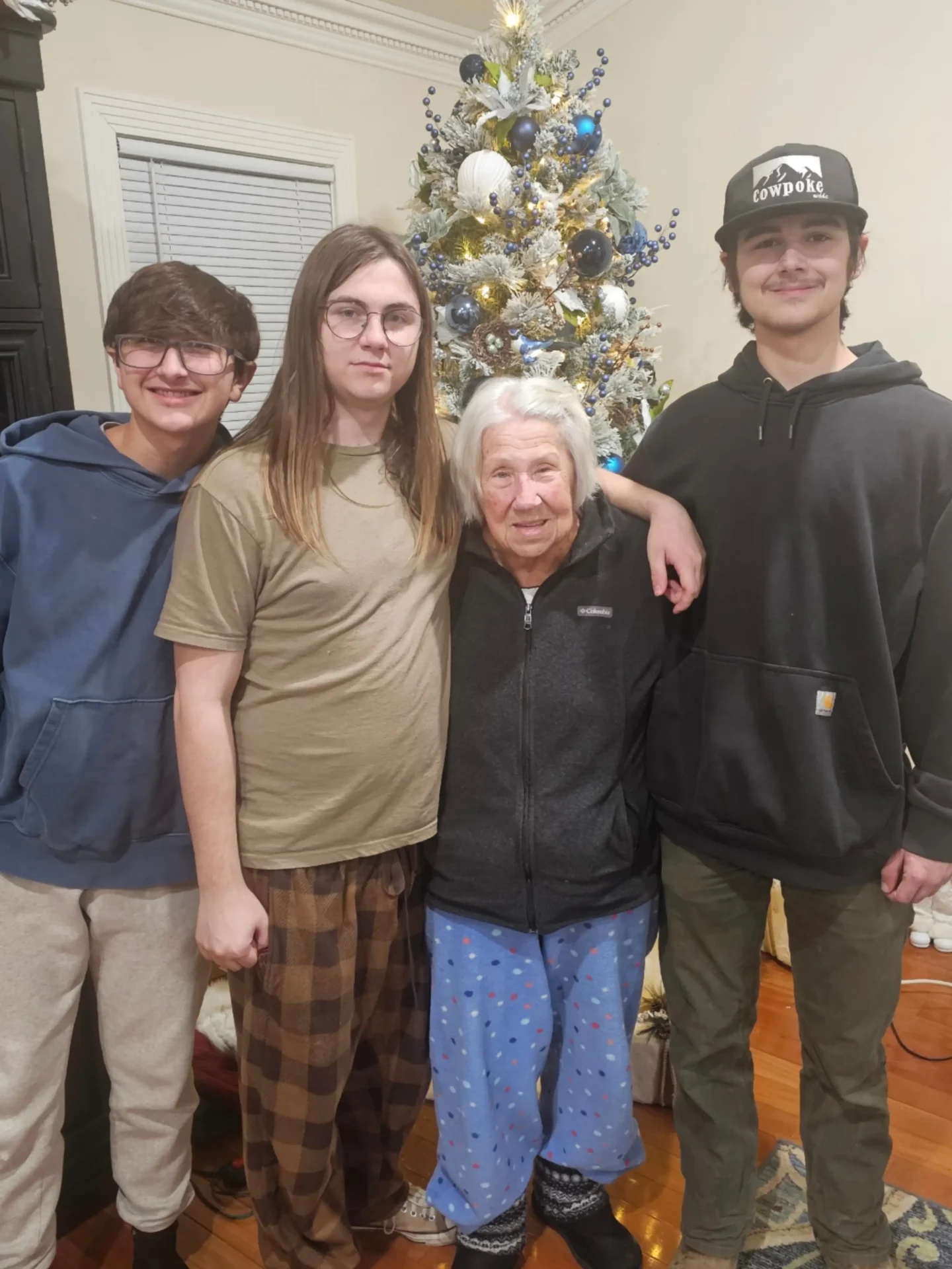 Family of four posing by Christmas tree