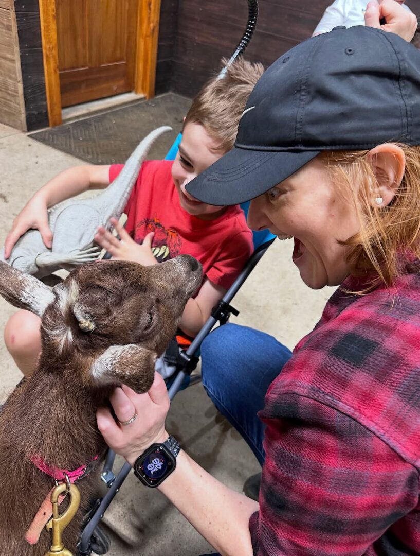 Woman and child petting a baby goat
