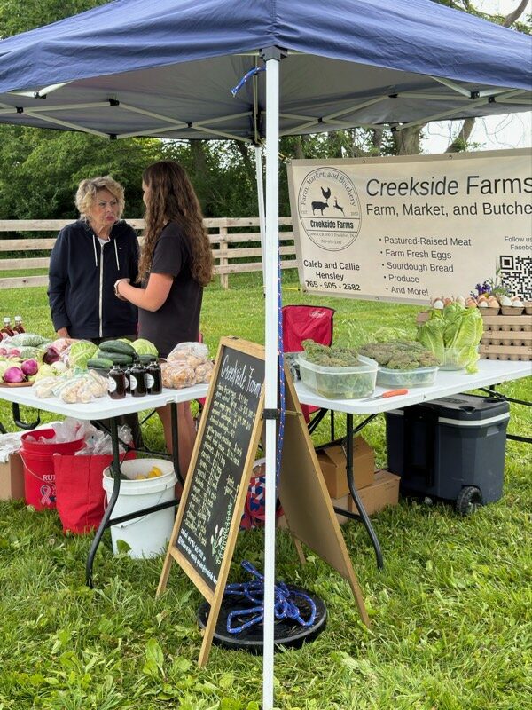Farmers market stall with produce and vendors
