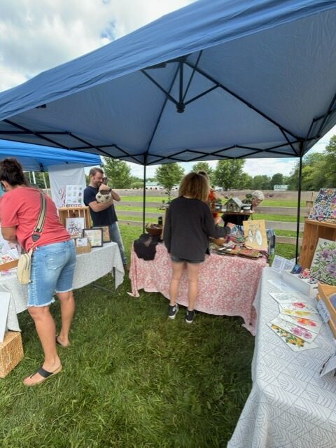 Outdoor craft fair booth with shoppers