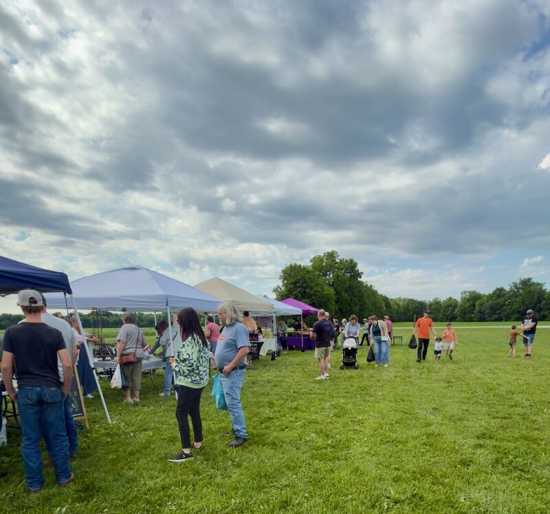 Outdoor market with tents and visitors