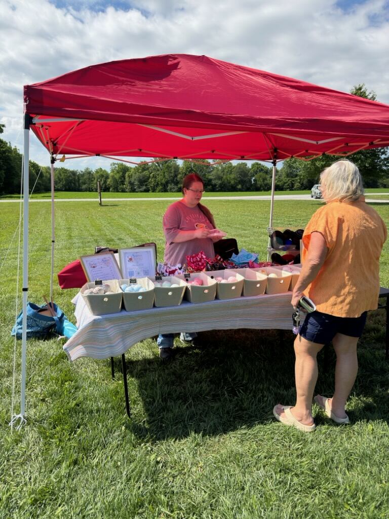 Vendor booth under red canopy at market
